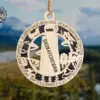 Saskatchewan wooden ornament with laser-cut prairie landmarks hanging against blue sky