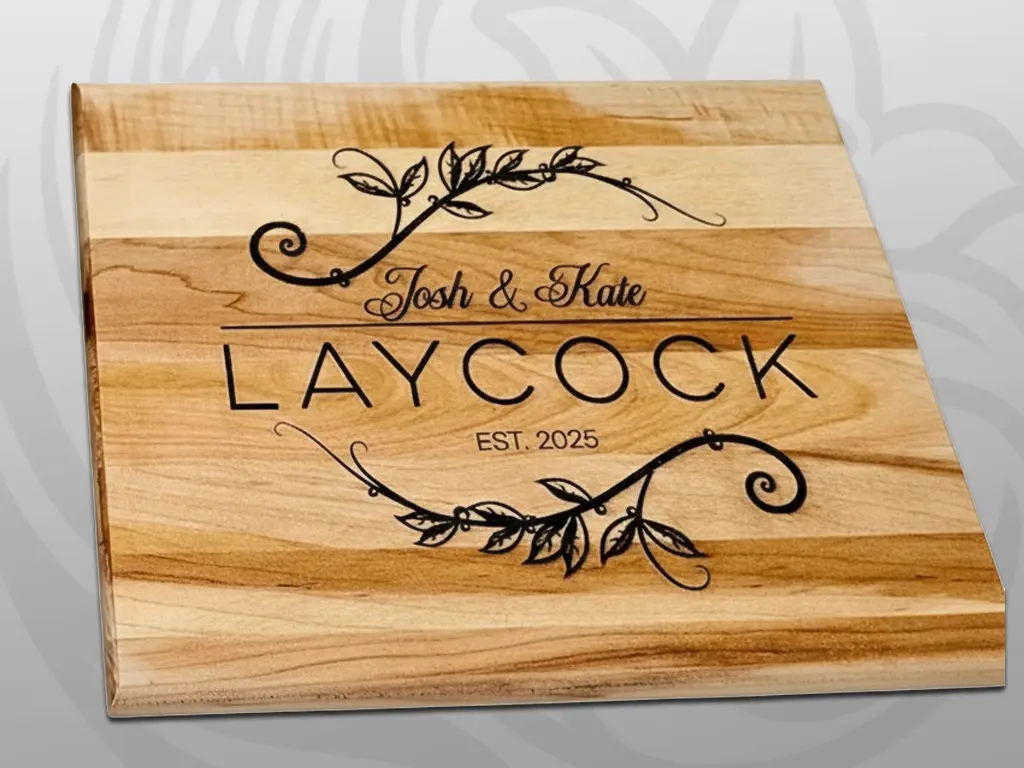 Wood serving board engraved with 'Josh & Kate Laycock Est. 2025' and decorative vine flourishes