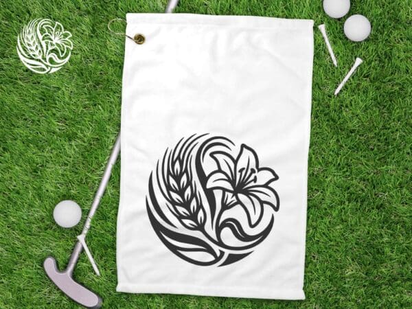 Poly linen sublimation golf towel with Saskatchewan Prairie Lily design and waffle weave texture displayed on grass with golf equipment