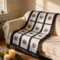 Nine panel sublimation blanket with black grid border and botanical medallion print draped over a cream sofa in a warm farmhouse living room with candles and greenery