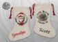 Two natural linen Christmas stockings with red drawstring ties — one featuring a watercolour Santa in a holly wreath with the name Grandpa in red script, the other a tangled Christmas lights design with the humorous text "I'm Fine, This Is Fine, Everything's Fine" and the name Scott in bold black