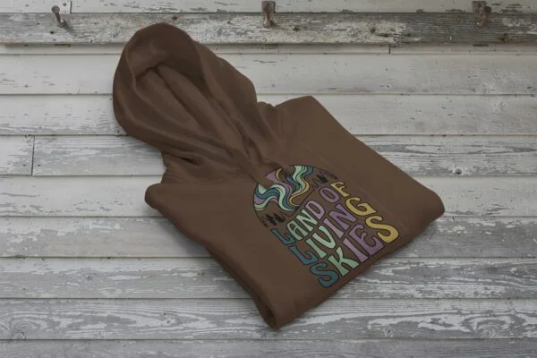 Land of Living Skies Bunnyhug displayed on rustic Saskatchewan barn wood background