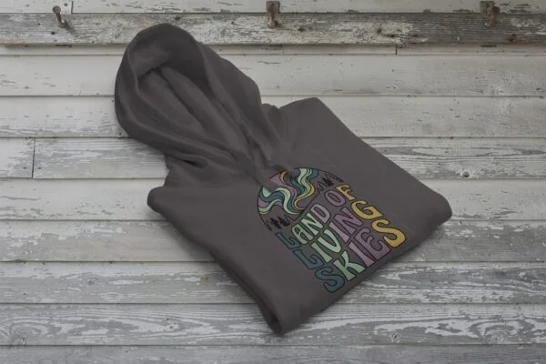 Land of Living Skies Bunnyhug displayed on rustic Saskatchewan barn wood background