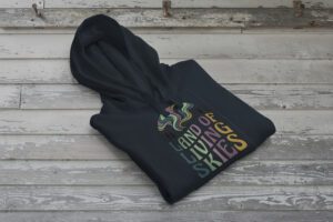 Land of Living Skies Bunnyhug displayed on rustic Saskatchewan barn wood background