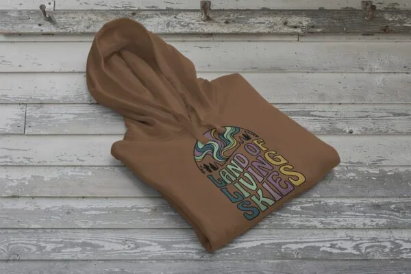 Land of Living Skies Bunnyhug displayed on rustic Saskatchewan barn wood background