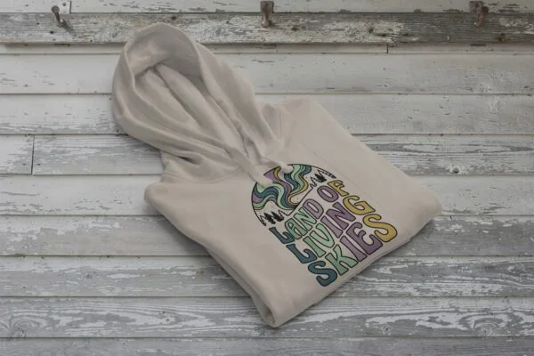 Land of Living Skies Bunnyhug displayed on rustic Saskatchewan barn wood background