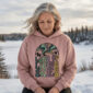 Land of Living Skies Bunnyhug displayed on a 50s woman winter camping