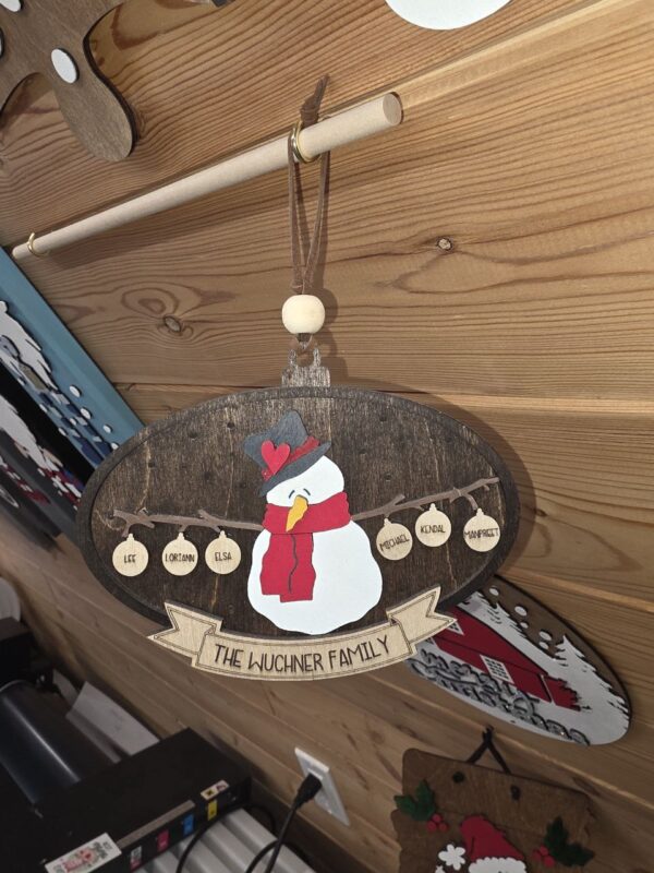 Laser-engraved wooden snowman ornament — one of the custom orders Saskatchewan families request most, handcrafted in the Grey Barn Handwerk workshop
