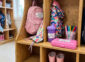 Name labels on rubber boots, a backpack, sippy cup, pencil case and markers in a school cubby